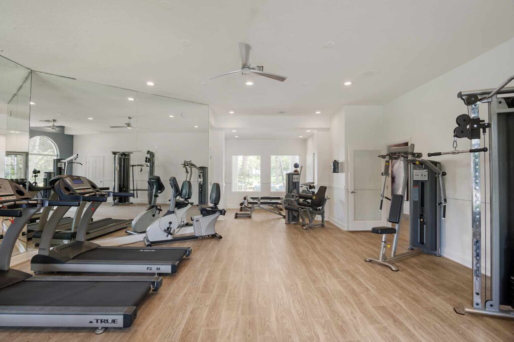 Fitness center with cardio and strength training machines and dumbells